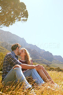 Buy stock photo Romance, kiss and love with couple in nature for carefree, bonding or affectionate. Happiness, date and relax with man and woman cuddling in grass field for summer break, happy or relationship mockup