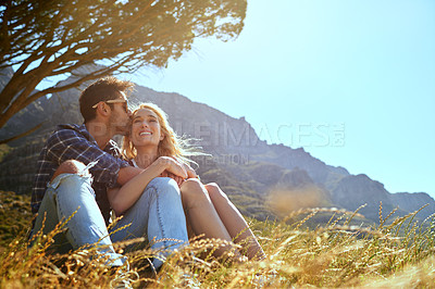 Buy stock photo Shot of an affectionate young couple enjoying a day outdoors