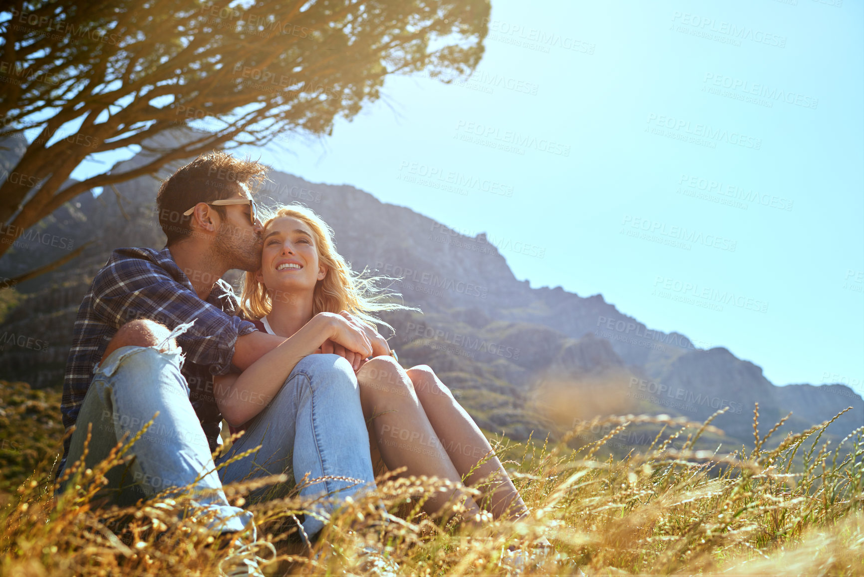 Buy stock photo Shot of an affectionate young couple enjoying a day outdoors