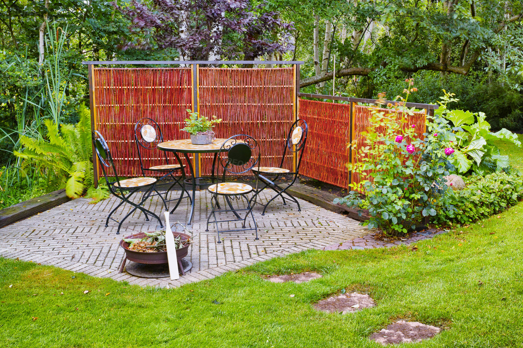 Buy stock photo Chairs and a table in a beautiful garden or botanical area during spring or summer. Outdoor furniture in the backyard with lush green plants and flowers. A peaceful, serene, and private area at home