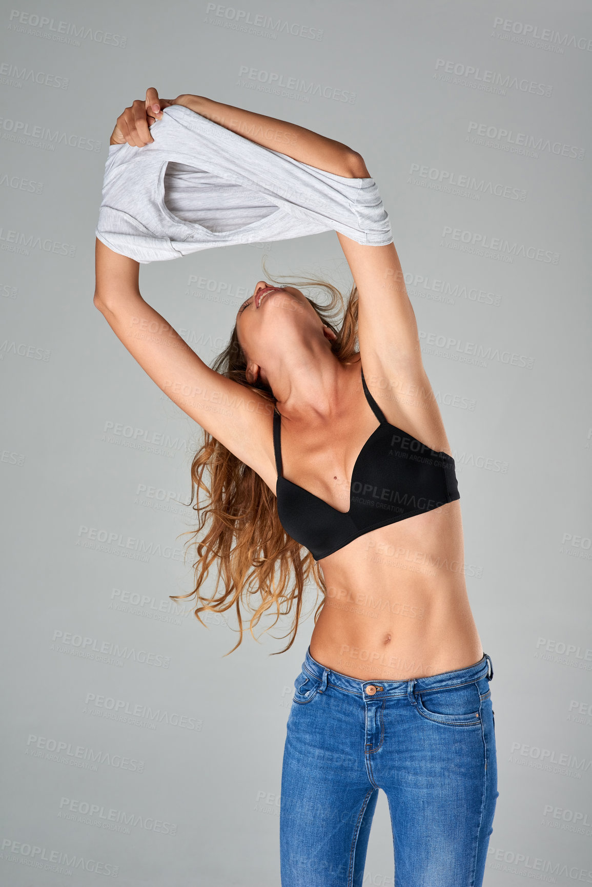 Buy stock photo Body, woman and take off shirt for fashion in studio, trendy or slender style isolated on white background. Jeans, bra and person undress clothes with underwear, lingerie or slim model getting ready