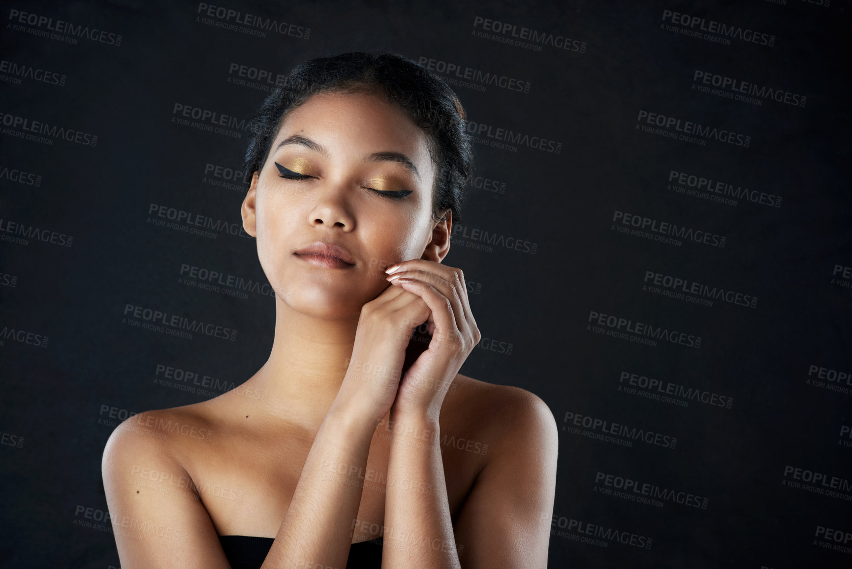 Buy stock photo Shot of a beautiful woman posing against a black background