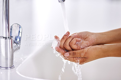 Buy stock photo Cropped shot of a woman washing her hands at a sink