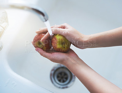Buy stock photo Shot of a person washing apples at a tap