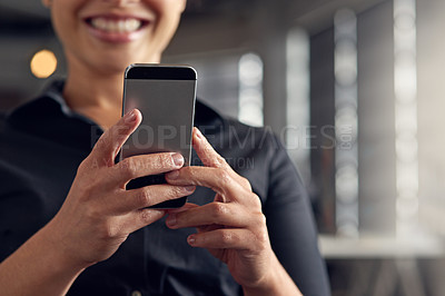 Buy stock photo Shot of a young businesswoman using her cellphone at the office