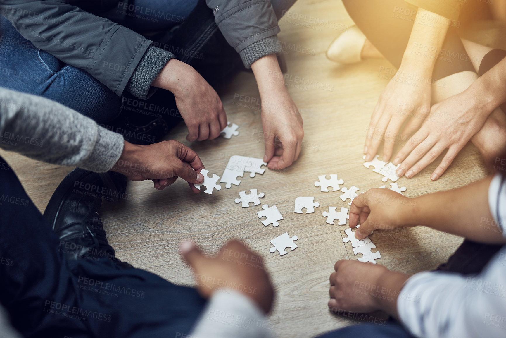 Buy stock photo Shot of a group of people building a puzzle together