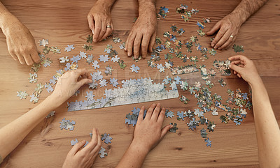 Buy stock photo Shot of a group of people building a puzzle together