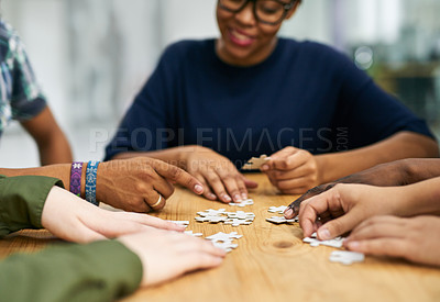 Buy stock photo Shot of a group of people building a puzzle together