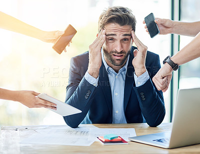 Buy stock photo Portrait of a young businessman sitting at a desk surrounded by hands reaching in holding items
