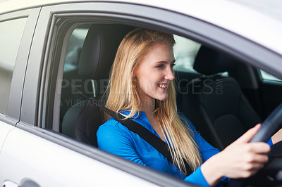 Buy stock photo Shot of a young woman driving a car