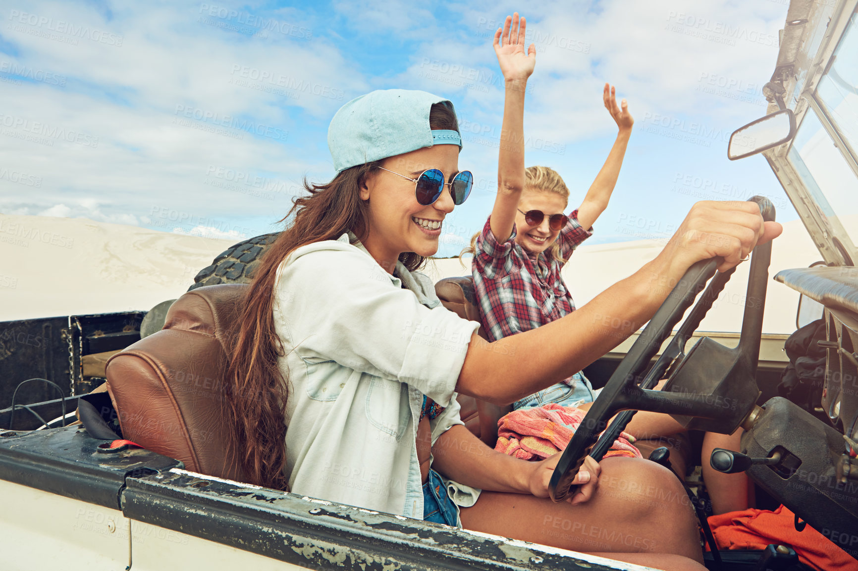 Buy stock photo Shot of two young friends going on a sand boarding road trip in the desert