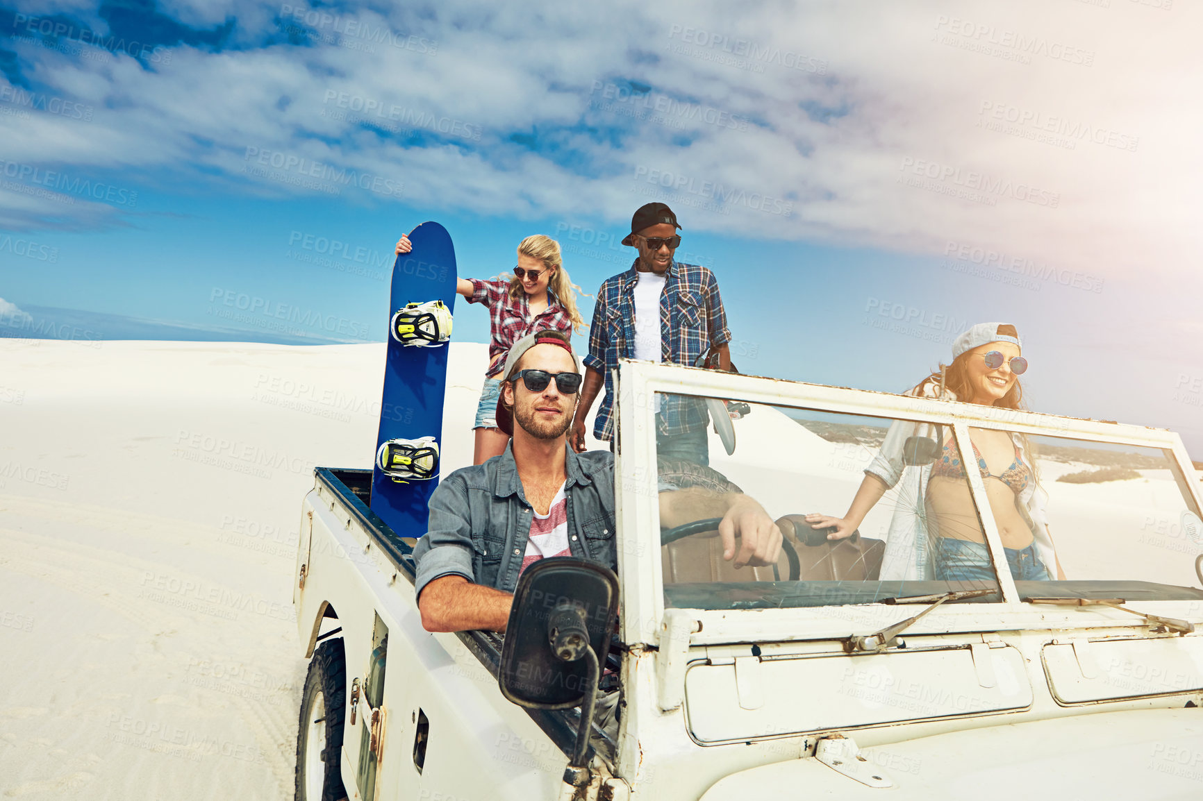 Buy stock photo Shot of a group of young friends going on a sand boarding road trip in the desert