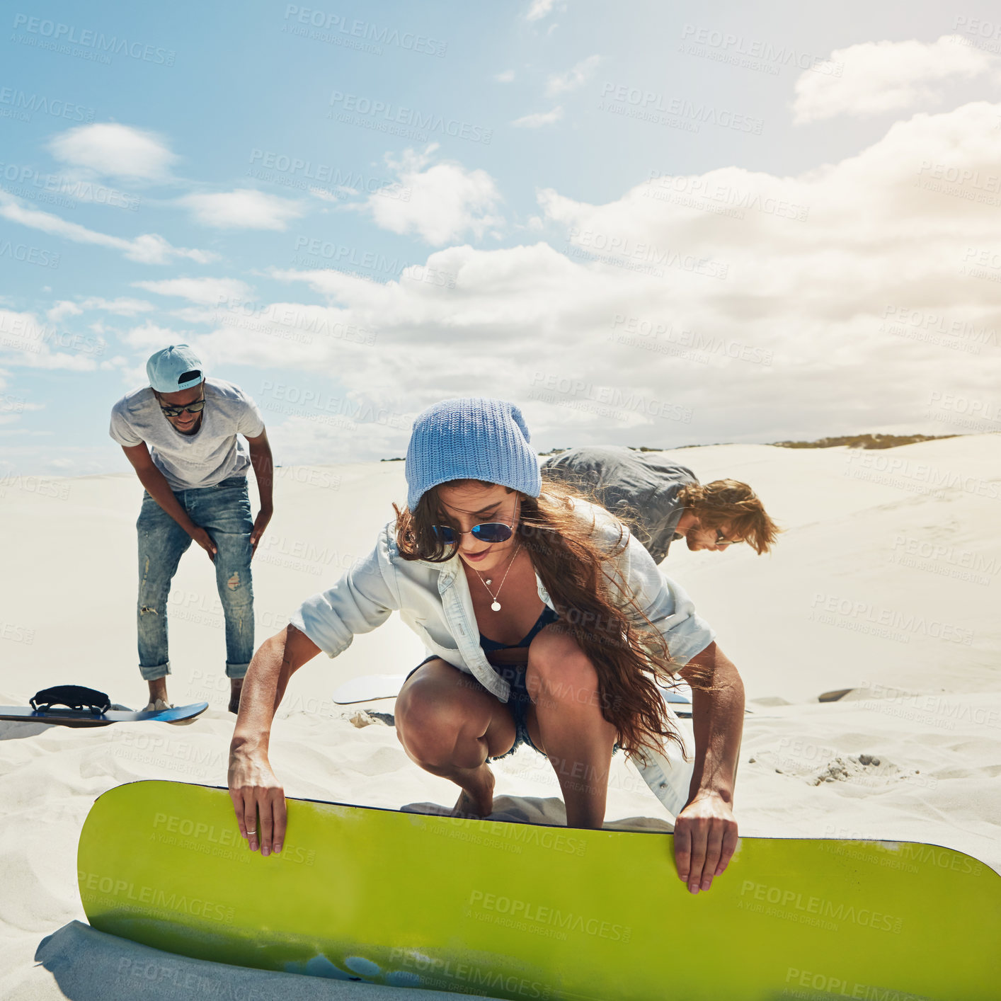 Buy stock photo Shot of young people sandboarding in the desert