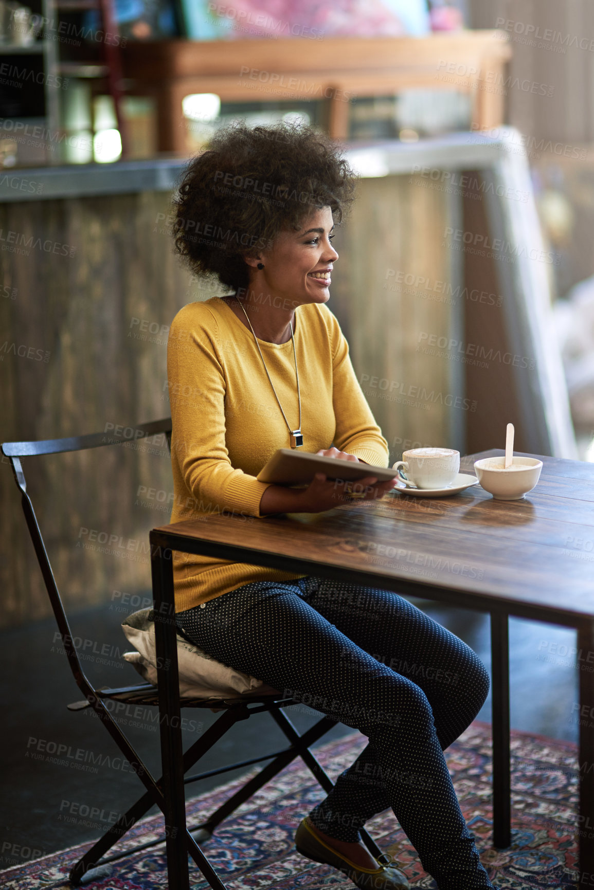 Buy stock photo Shot of a young woman using a digital tablet in a cafe