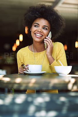 Buy stock photo Shot of a young woman talking on a cellphone in a cafe