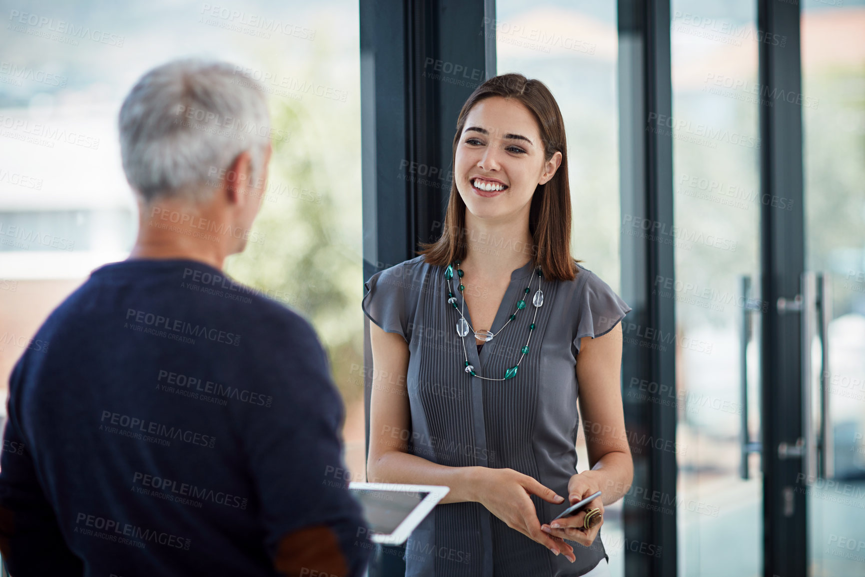 Buy stock photo Shot of two colleagues talking in an office