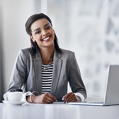 Buy stock photo Portrait of a young businesswoman using a laptop while sitting at a desk in an office