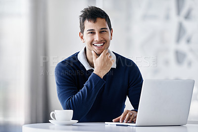 Buy stock photo Portrait of a smiling young businessman using a laptop while sitting at a desk in an office