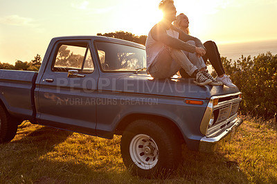 Buy stock photo Travel, sunset and couple relax on car for road trip break, holiday adventure and sightseeing together. Lens flare, happy people and view of nature for scenery, weekend vacation or exploring on truck