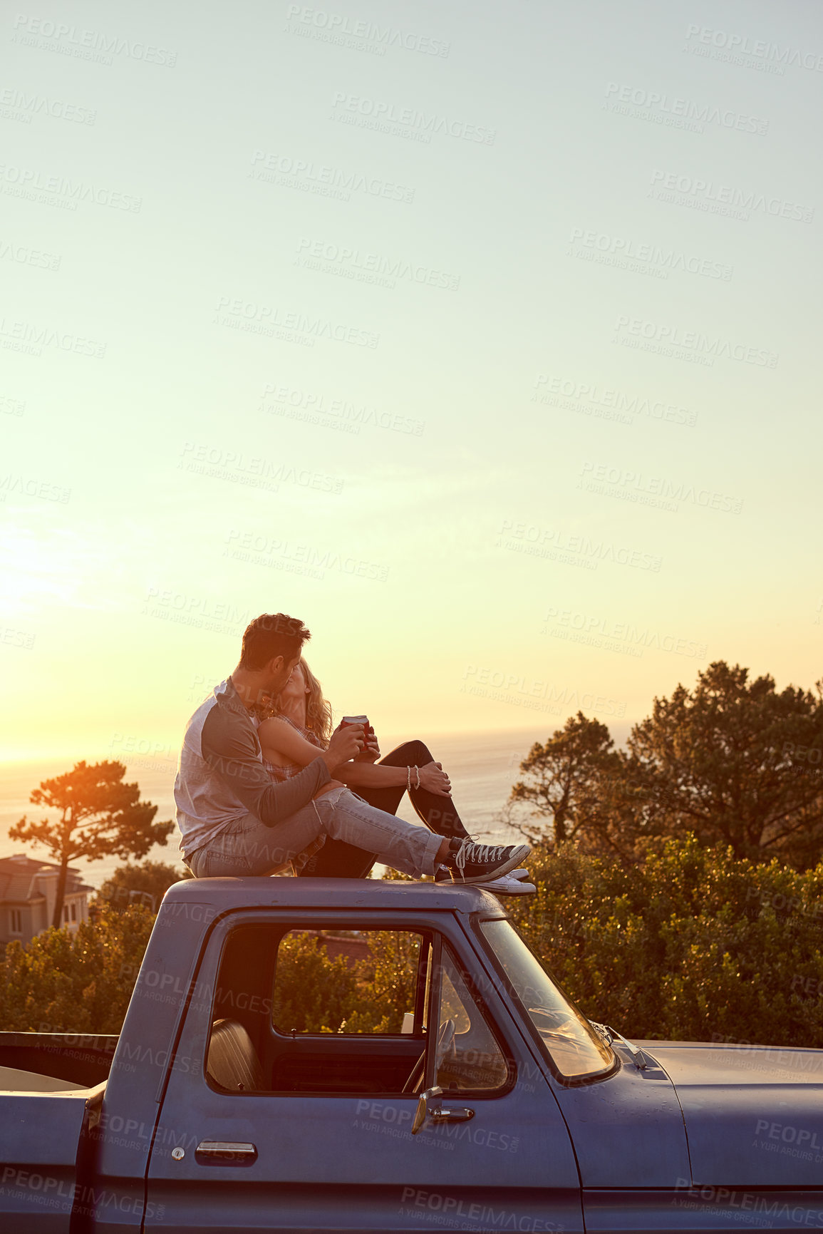 Buy stock photo Shot of an affectionate young couple on a roadtrip