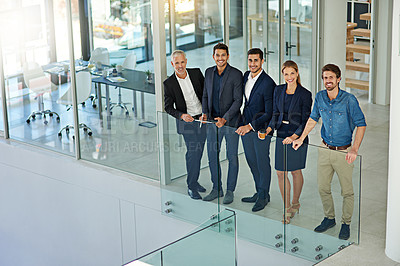 Buy stock photo Portrait of a group of smiling colleagues standing together in a modern office