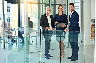 Buy stock photo Portrait of three colleagues standing together in a modern office