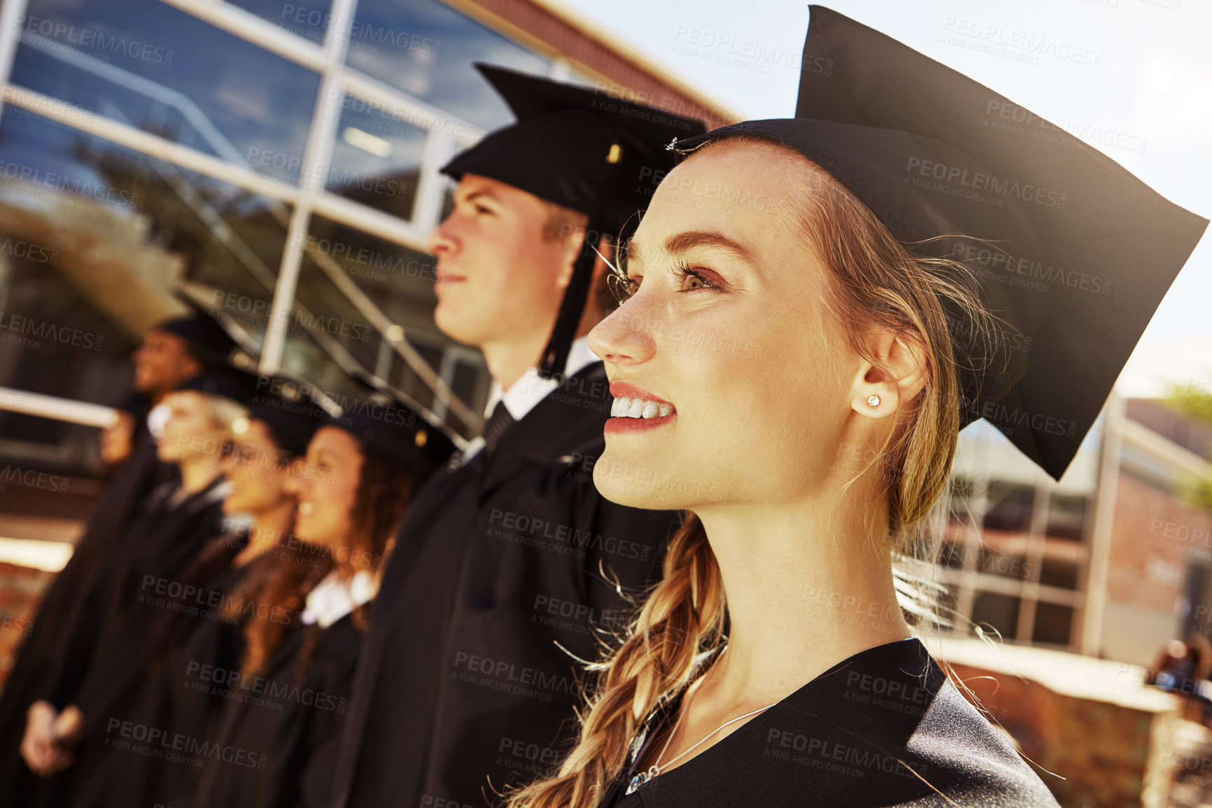 Buy stock photo Shot of students standing outside on graduation day from university