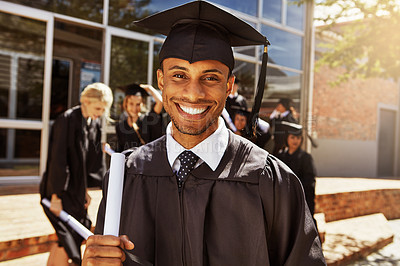Buy stock photo Portrait of a smiling university student holding his diploma outside on graduation day