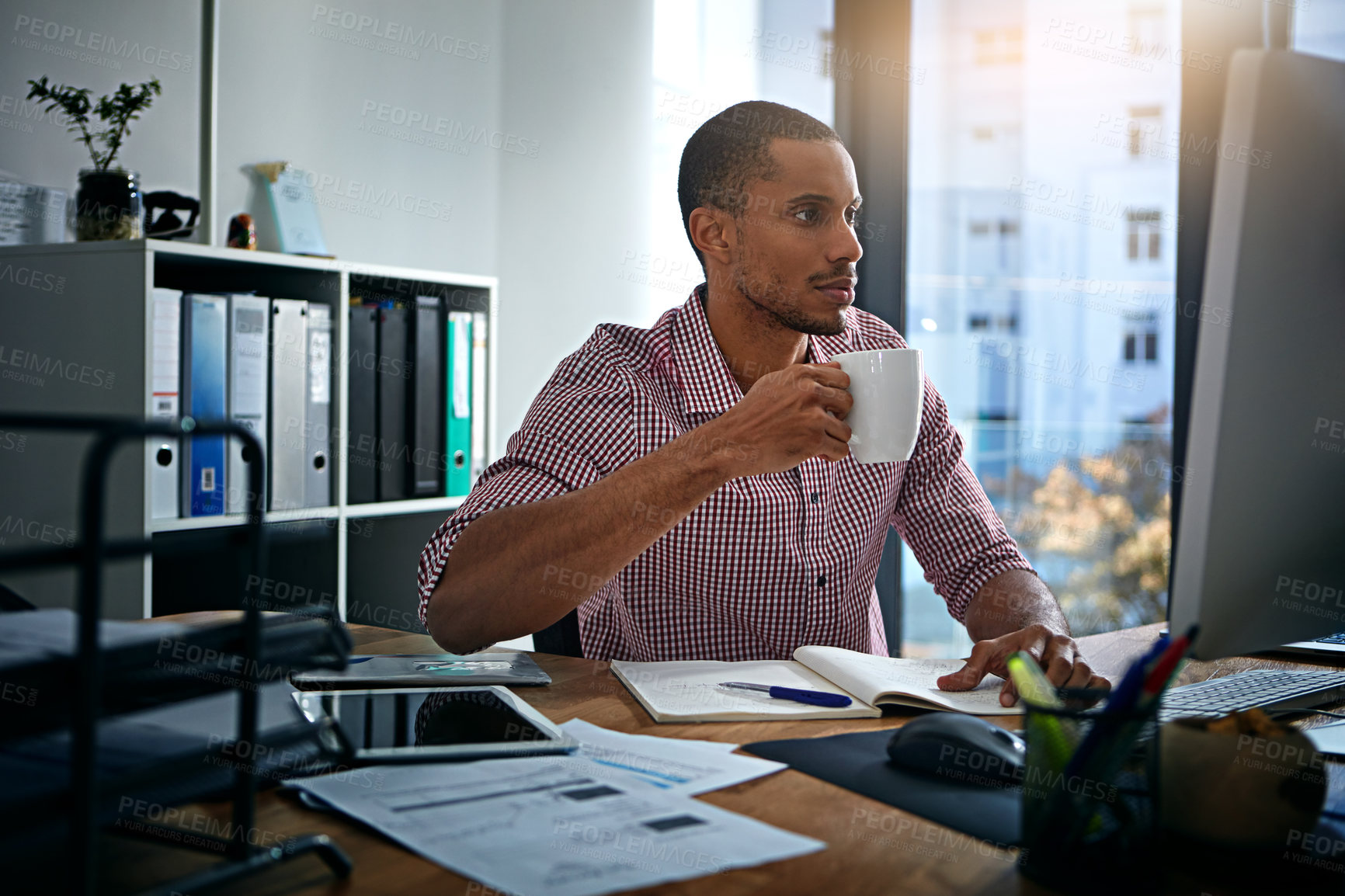 Buy stock photo African businessman, coffee and reading at computer, office and planning with vision, goal and start morning. Corporate black man, pc and notebook for strategy, mission and email for communication