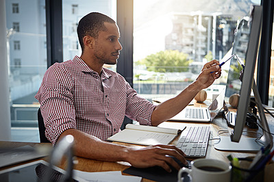 Buy stock photo Shot of a businessman working on a computer in an office