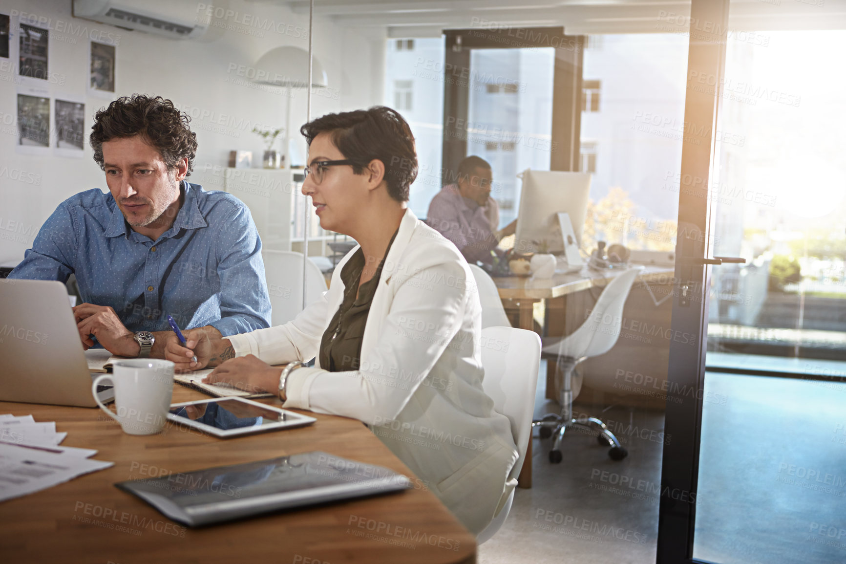 Buy stock photo Shot of businesspeople working on a laptop in an office