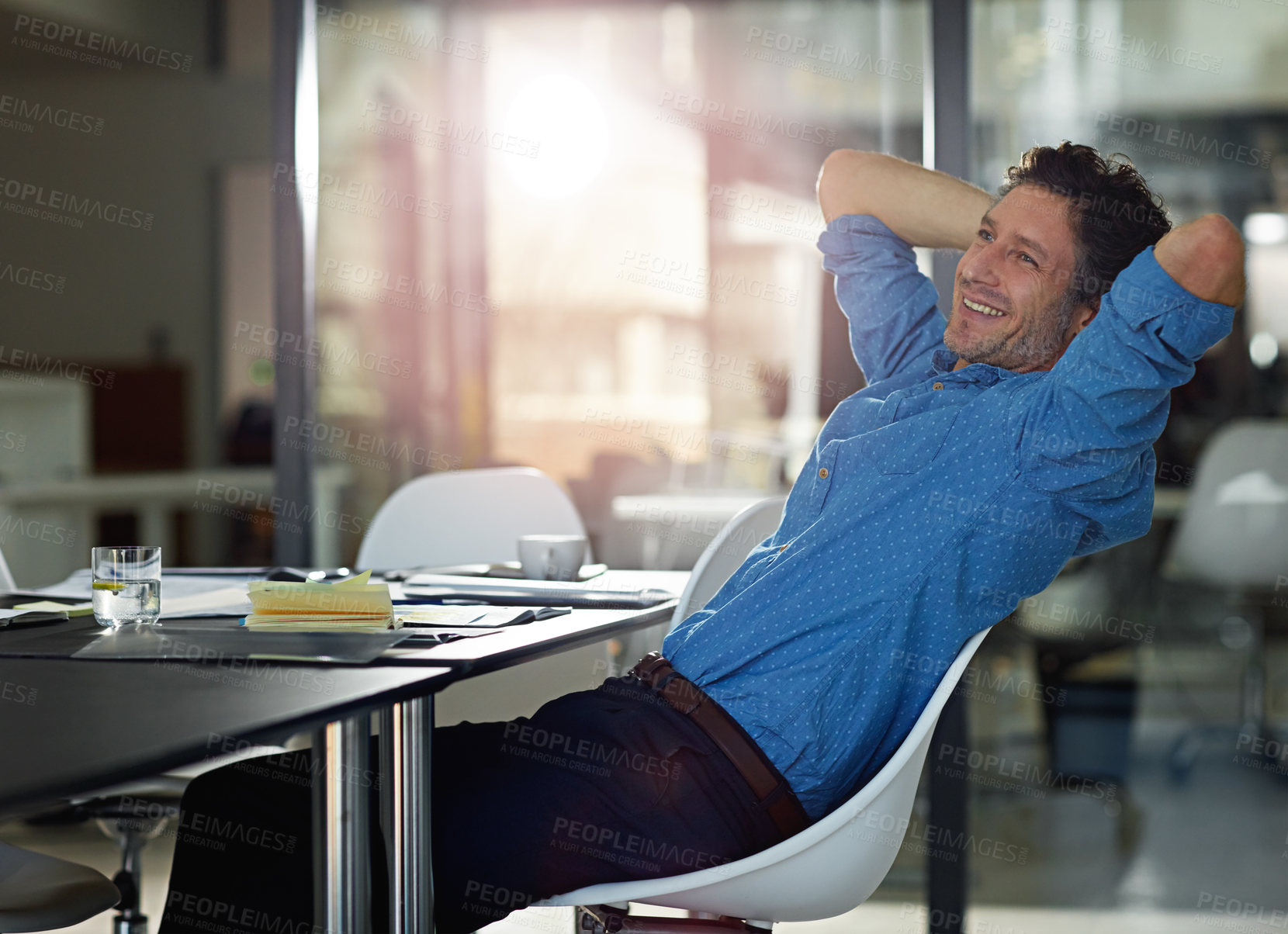 Buy stock photo Cropped shot of a businessman sitting with his hands behind his head in the office