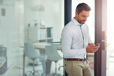 Buy stock photo Shot of a businessman using a cellphone in an office