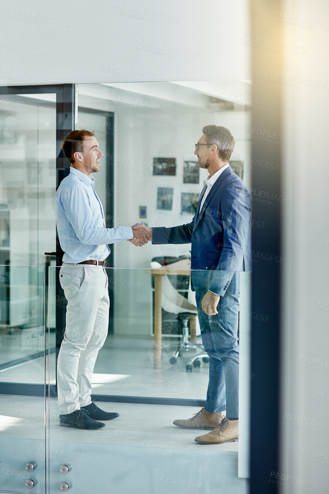 Buy stock photo Shot of two businessmen shaking hands in an office