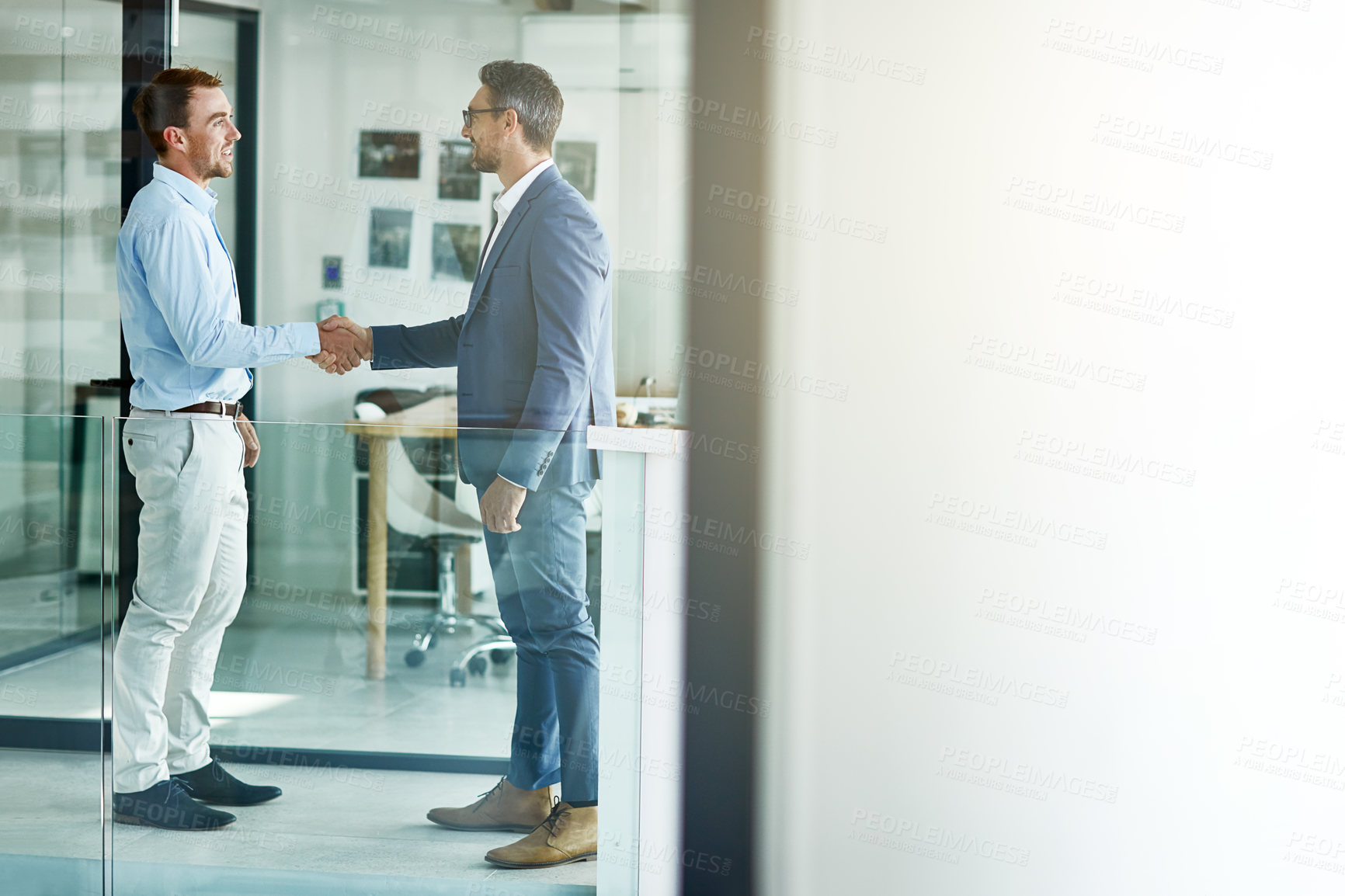 Buy stock photo Shot of two businessmen shaking hands in an office