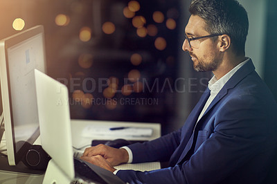 Buy stock photo Shot of a businessman using a laptop while woking late at the office