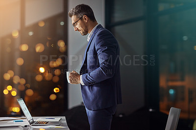 Buy stock photo Shot of a businessman using a laptop while woking late at the office