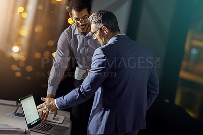 Buy stock photo Shot of a coworkers using a laptop together while woking late at the office