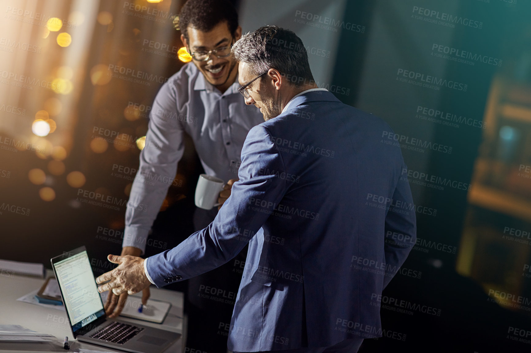 Buy stock photo Shot of a coworkers using a laptop together while woking late at the office