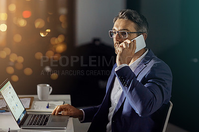 Buy stock photo Shot of a businessman using his phone while woking late in the office