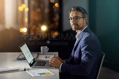 Buy stock photo Shot of a businessman using a laptop while woking late at the office