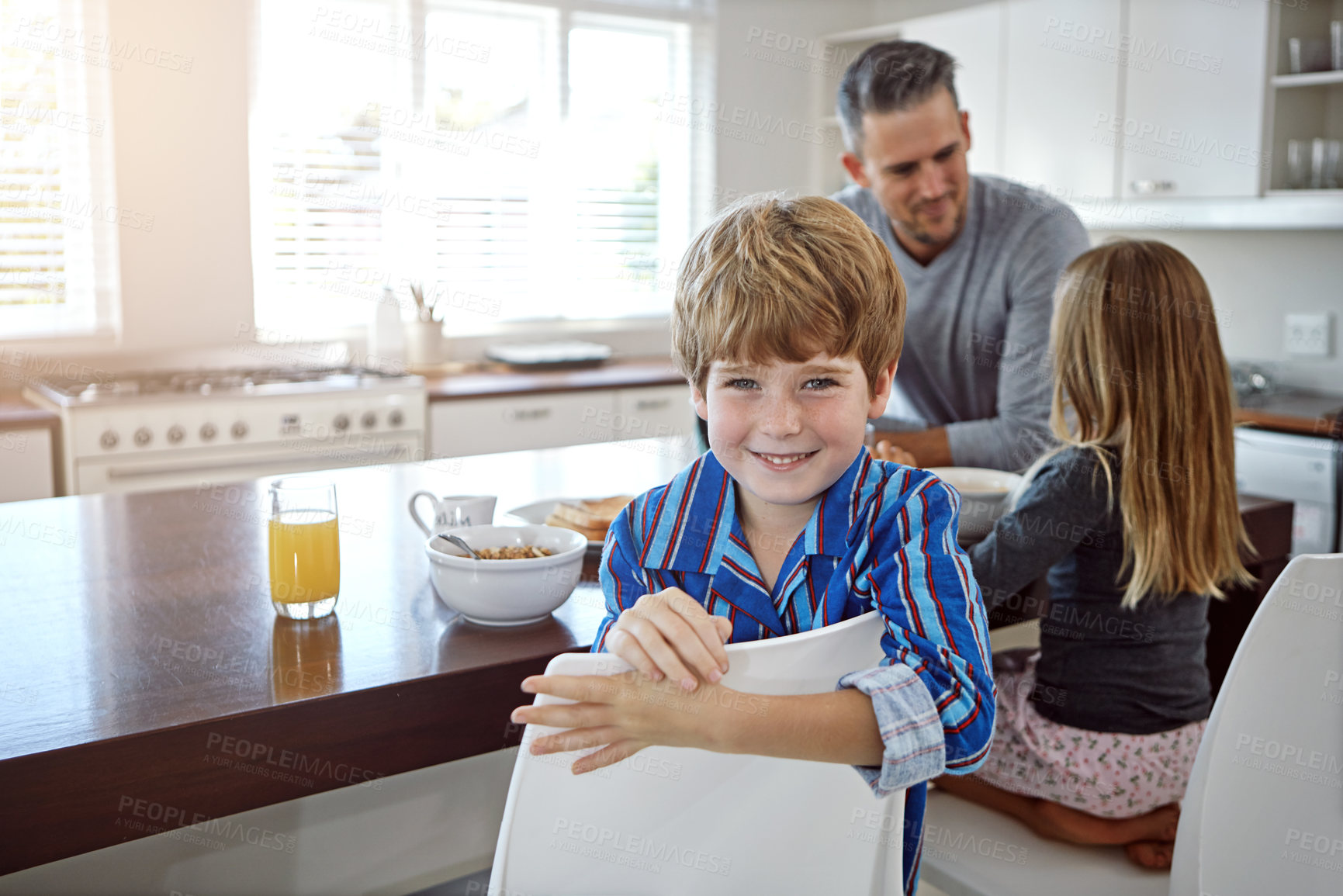 Buy stock photo Happy child, breakfast and cereal with family in kitchen for morning nutrition, vitamin C or orange juice at home. Father, boy or son with smile for meal, snack or healthy eating together at house