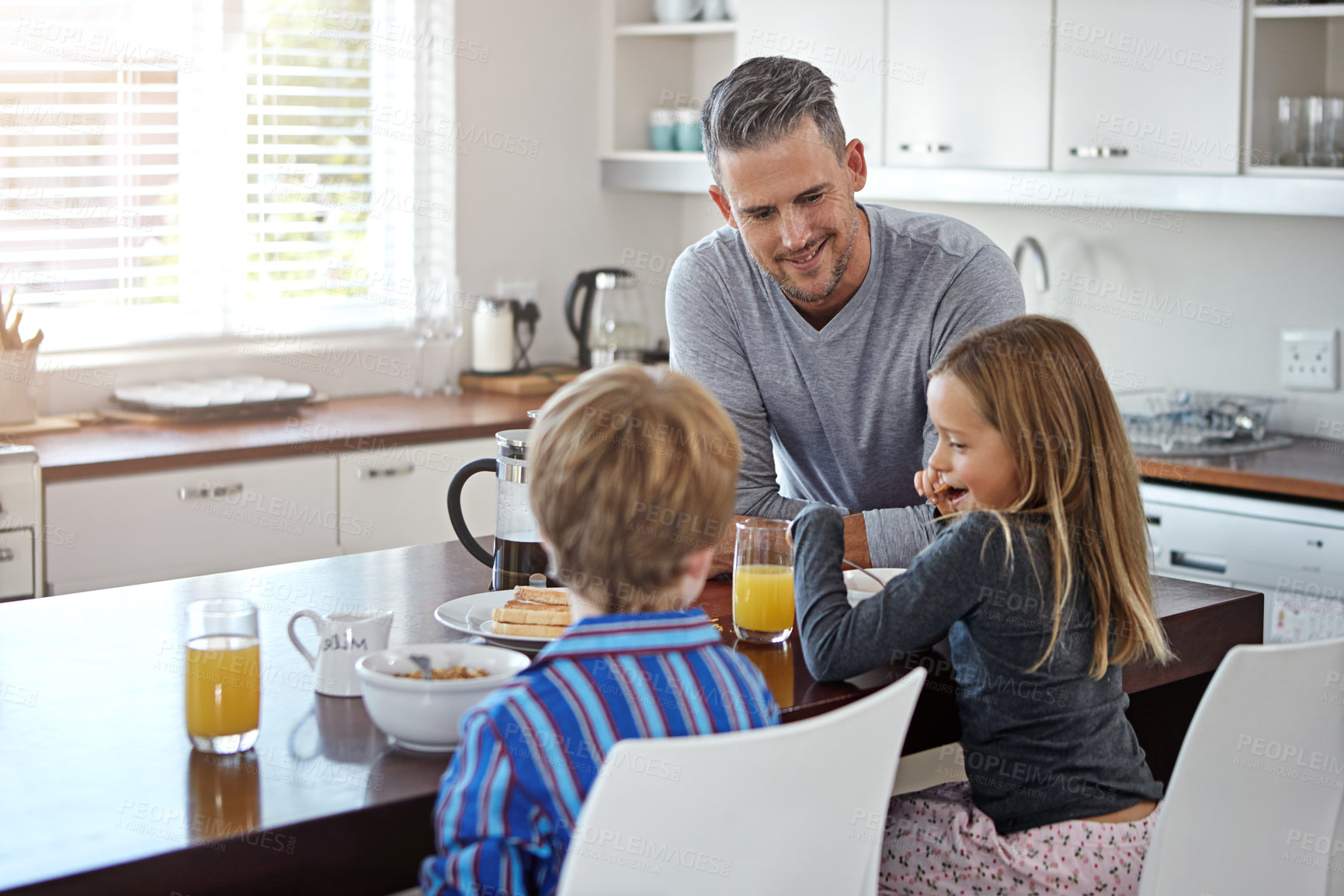 Buy stock photo Kitchen counter, father and happy with kids in home with funny conversation, support and care. Apartment, people and smile as parent with family time in morning for meal, bonding or child development