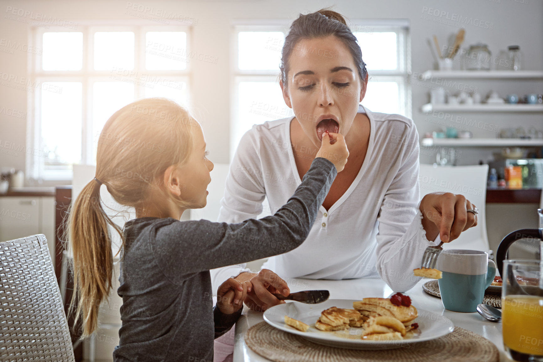 Buy stock photo Cropped shot of a mother and daughter having breakfast at home