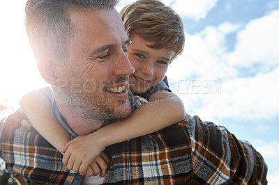 Buy stock photo Shot of a father and son enjoying a piggyback ride outdoors
