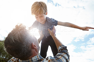 Buy stock photo Shot of a father lifting his son high into the air
