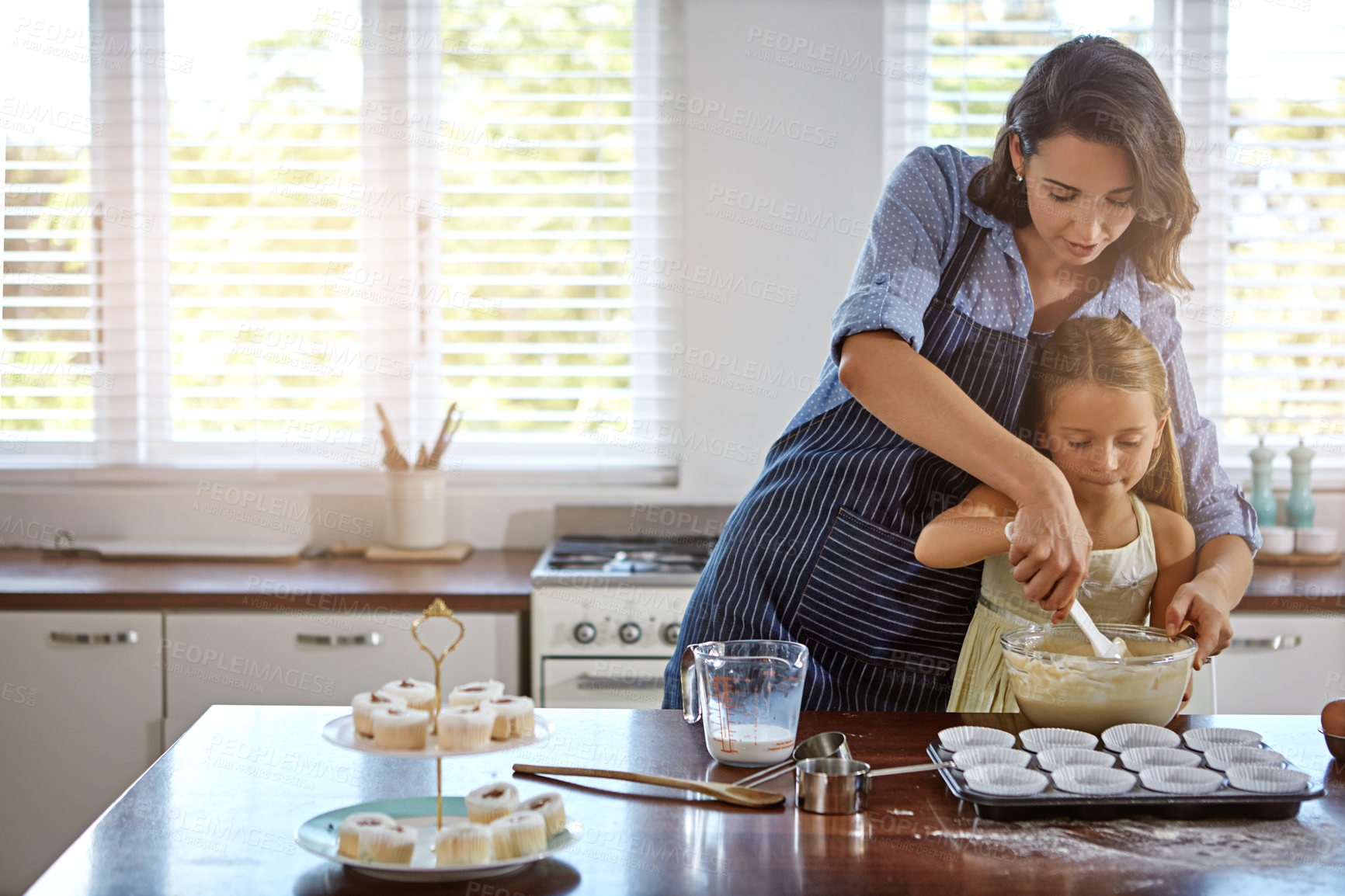 Buy stock photo Baking, home and mother with girl, help and learning with child development, smile and growth. Food, apartment and happy mama with daughter, ingredients and bonding together with recipe in kitchen