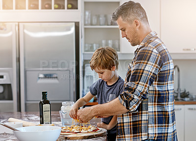 Buy stock photo Baking, dad and teaching of child, pizza and bonding with son in kitchen, serious and ingredients. Home, learning and help for father, meal prep and parent with boy, dinner and recipe for food