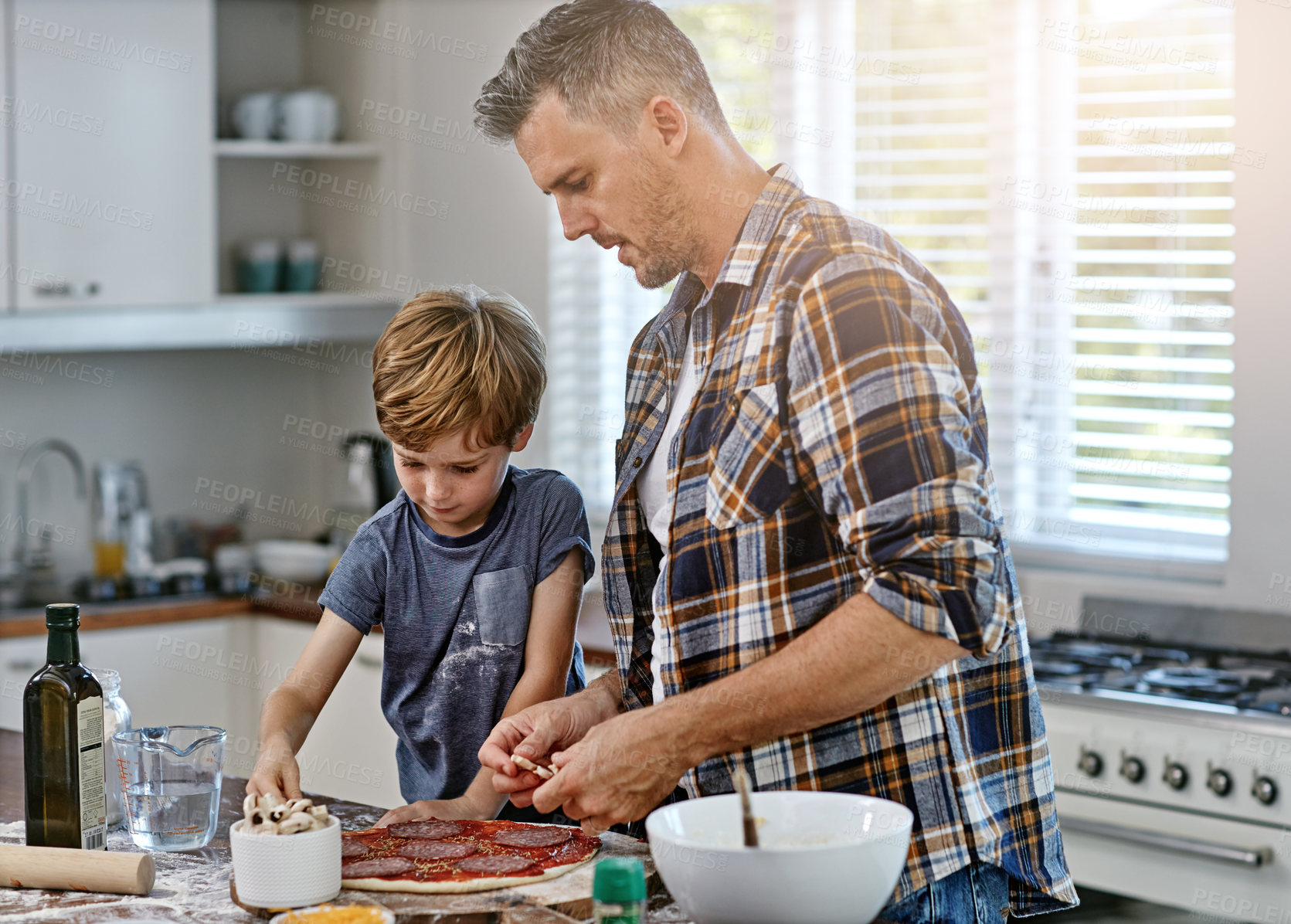 Buy stock photo Dad, child and cooking for teaching with pizza, toppings and help for dinner recipe in family home. Learning, father and son with preparation in kitchen with tomato, sauce and dough for baking skills