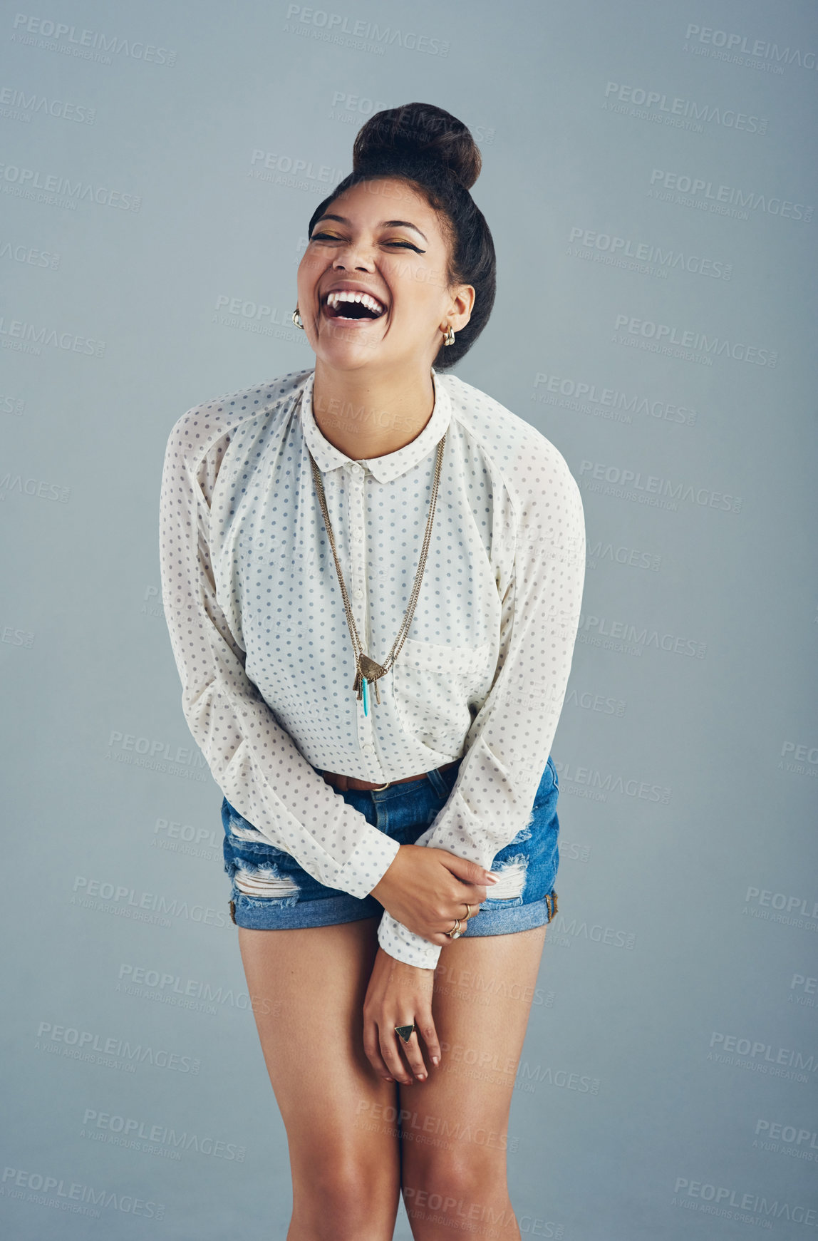 Buy stock photo Studio shot of an attractive young woman laughing against a gray background